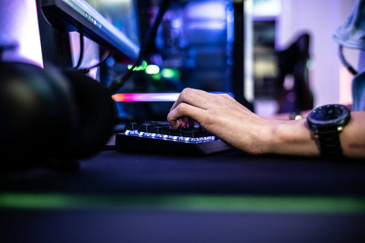 Close up shot of hand typing on a gaming keyboard