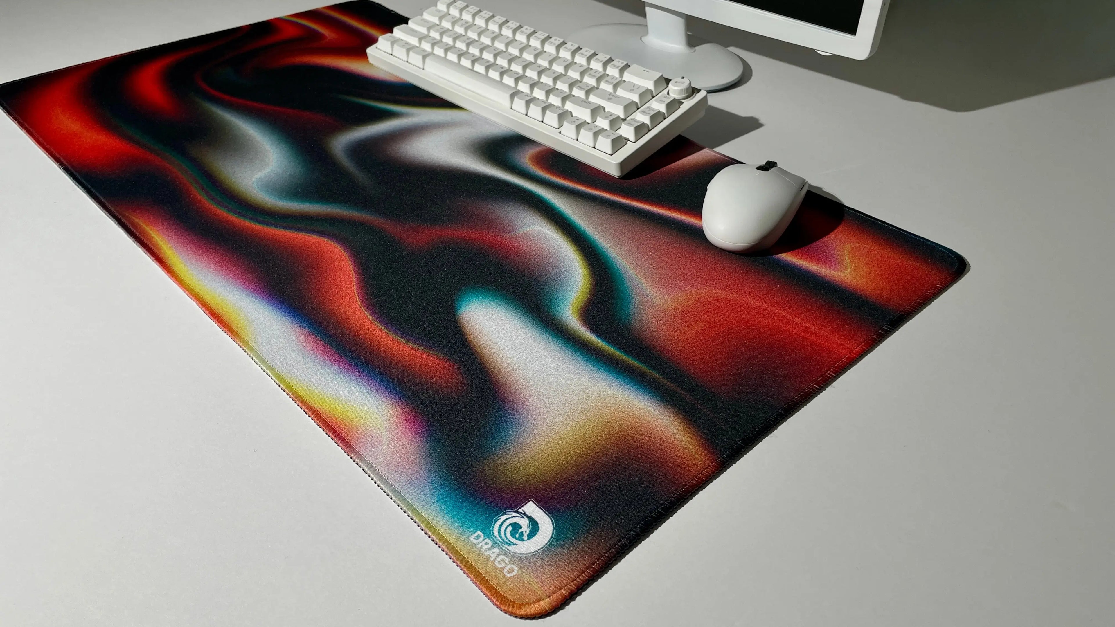 Colorful mouse pad with a swirling design on a desk with a keyboard and mouse.
