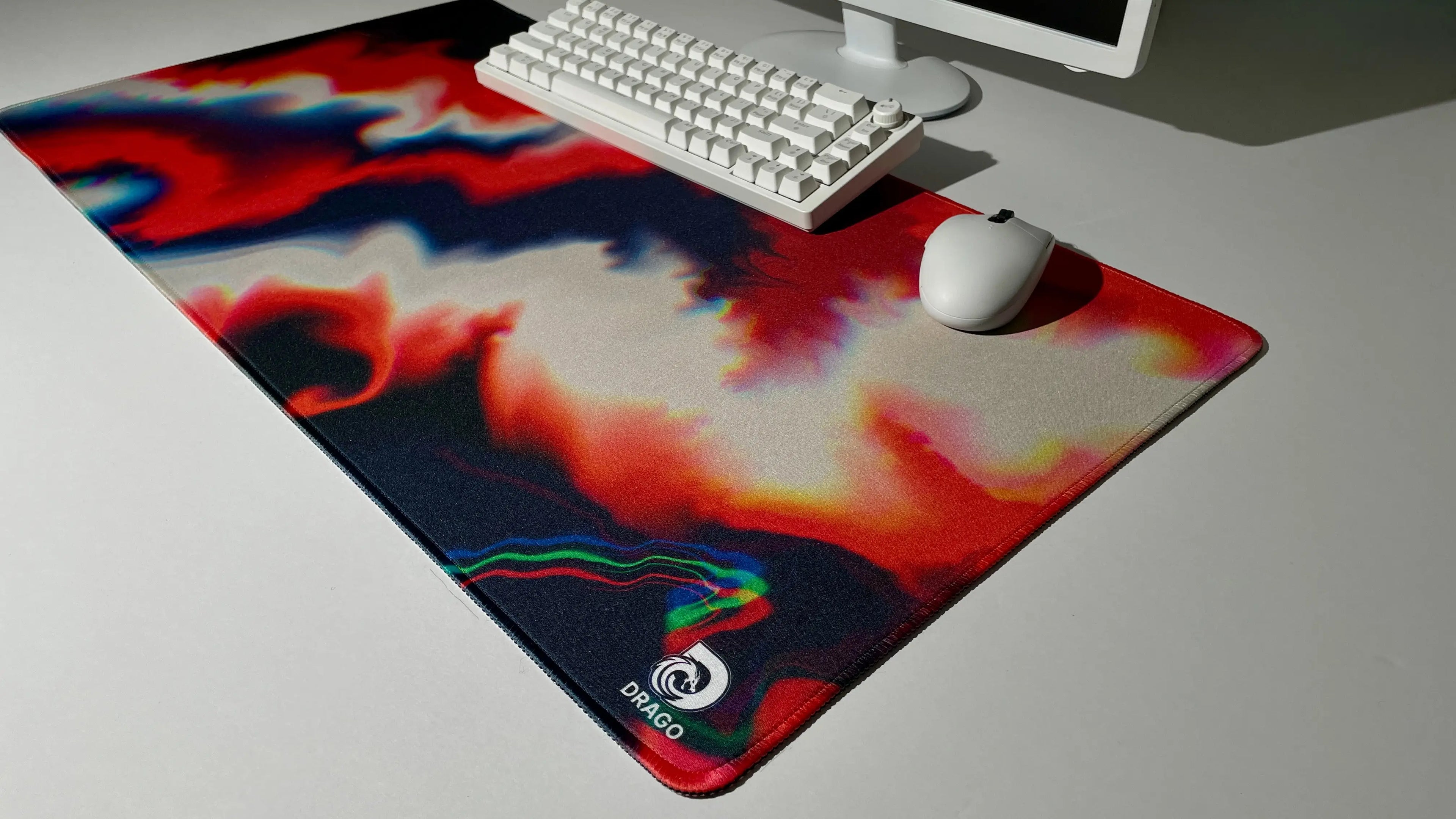 Orange and blue mouse pad with a swirling design on a desk with a keyboard and mouse.
